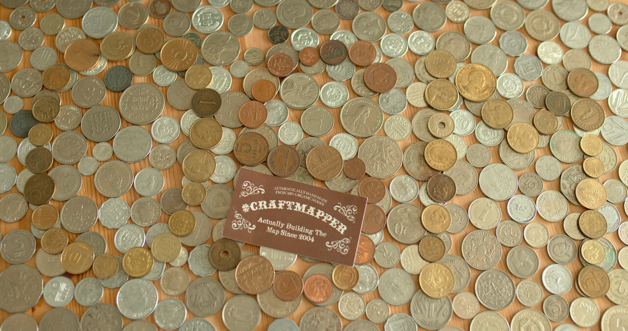 Foto eines Craftmapper-Aufkleber auf Münzen verschiedener Währungen